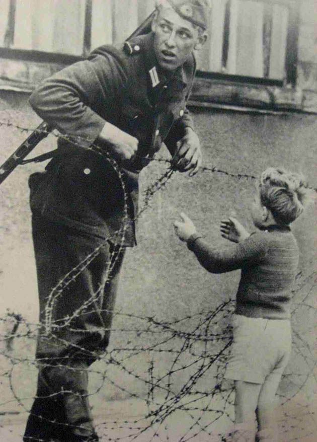 Niemiecki żołnierz pomaga dziecku przejść do Berlina Zachodniego.