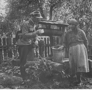 1927. Manewry terenowe. Wiejska dziewczyna częstuje wodą młodego porucznika
