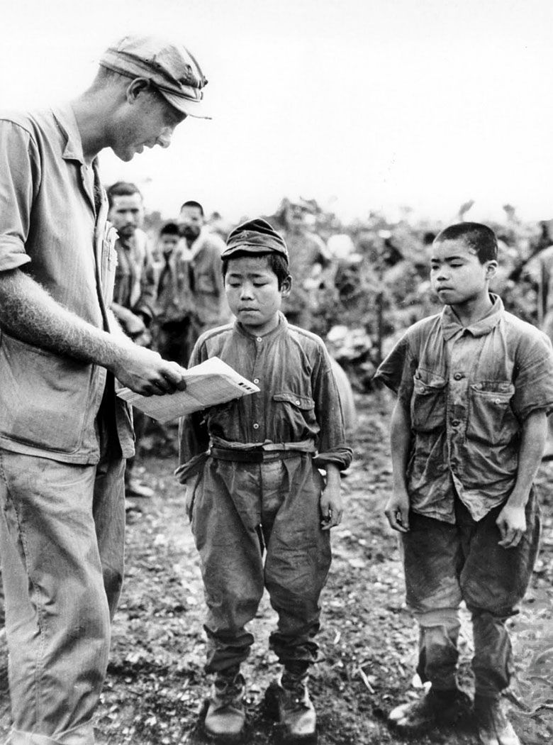 Amerykański żołnierz rozmawia z dwoma bardzo młodymi japońskimi żołnierzami (Bitwa o Okinawę, 17 czerwca 1945)