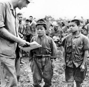 Amerykański żołnierz rozmawia z dwoma bardzo młodymi japońskimi żołnierzami (Bitwa o Okinawę, 17 czerwca 1945)