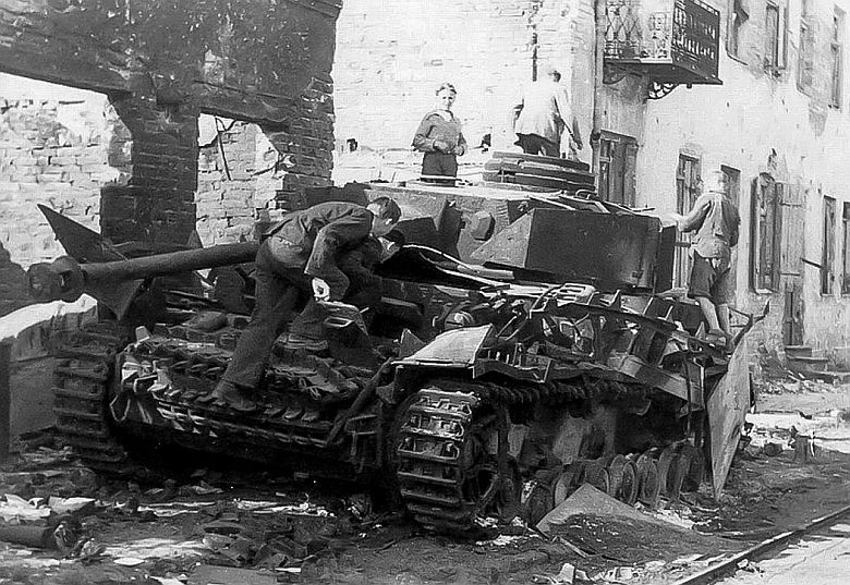 Warszawa 1944, zniszczony przez Powstańców niemiecki czołg Pz.Kpfw IV oglądany przez cywili przy ul. Grochowskiej 14