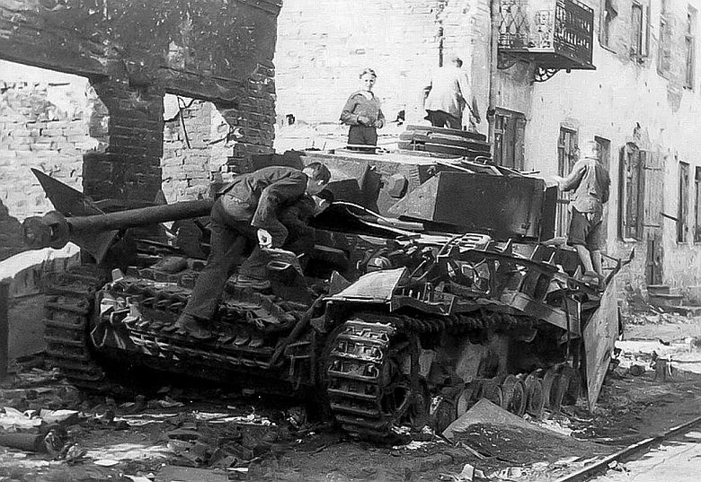 Warszawa 1944, zniszczony przez Powstańców niemiecki czołg Pz.Kpfw IV oglądany przez cywili przy ul. Grochowskiej 14