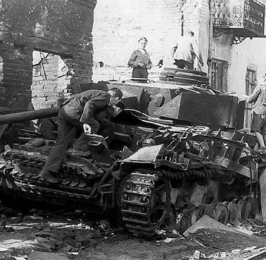 Warszawa 1944, zniszczony przez Powstańców niemiecki czołg Pz.Kpfw IV oglądany przez cywili przy ul. Grochowskiej 14
