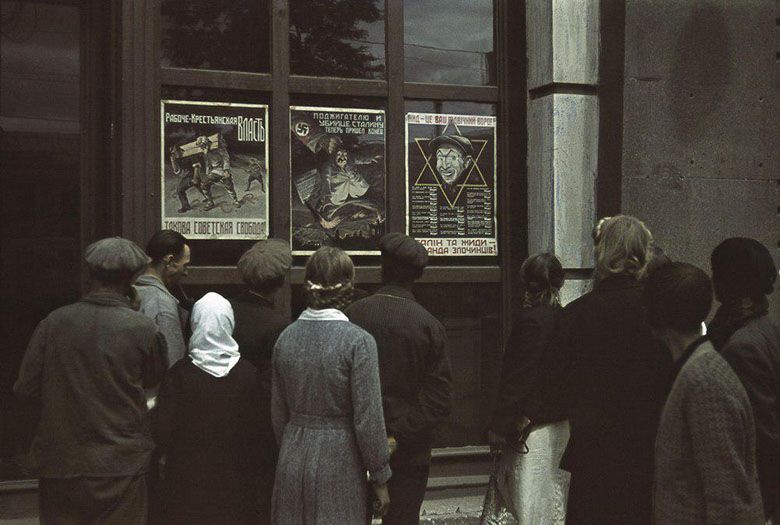 Niemieckie plakaty propagandowe w witrynie sklepu w okupowanym Charkowie, 1942
