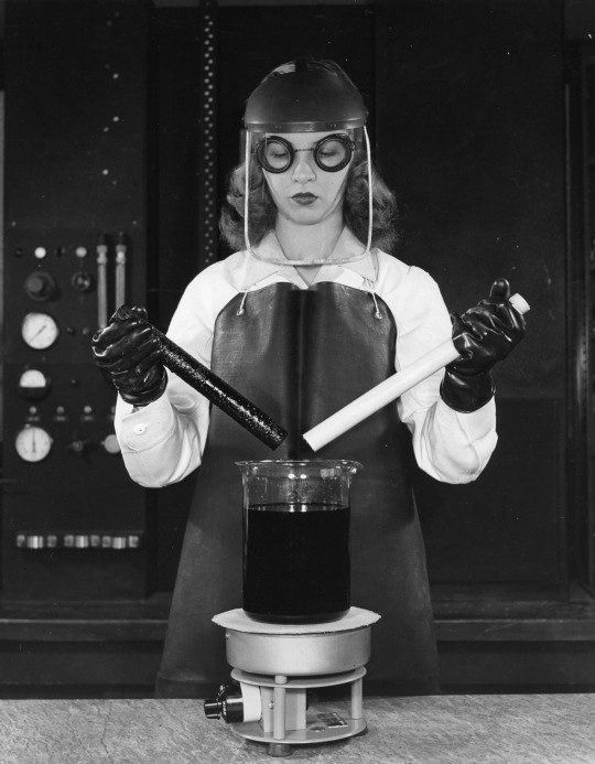 Technik laboratoryjny wkłada dwa plastikowe pręty do gorącego kwasu siarkowego, w efekcie czego ma powstać teflon, 1949
