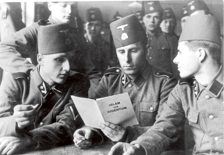 Muzułmańscy bośniaccy żołnierze z Waffen SS podczas lektury broszurki propagandowej o różnicach między muzułmanami a żydami