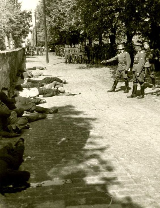 Oficer armii niemieckiej podczas dobijania rozstrzelanych zakładników, Pančevo, Jugosławia, 1941