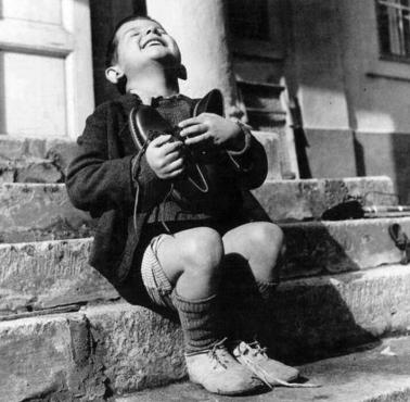 Austriacki chłopie cieszy się z nowych butów otrzymanych z darów Czerwonego Krzyża z USA, 1947