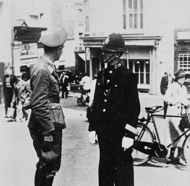 Oficer Luftwaffe rozmawia z brytyjskim policjantem na ulicy Jersey. Wyspy Normandzkie były okupowane przez Niemcy w czasie wojny