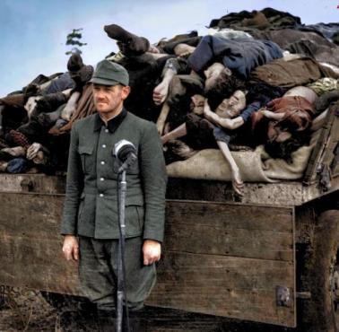 Niemiec Franz Hößler stoi przed ciężarówką przewożącą ciała więźniów z obozu