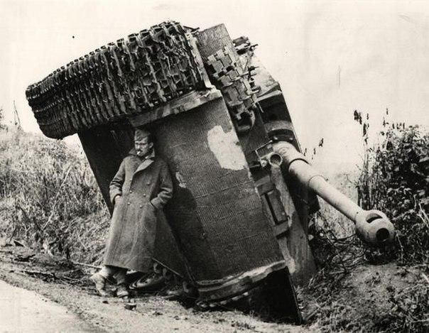 Brytyjski żołnierz ukrywa się przed deszczem pod niemieckim Tygrysem, 1944