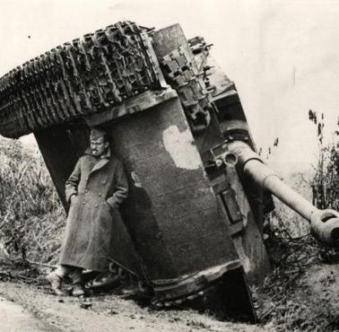 Brytyjski żołnierz ukrywa się przed deszczem pod niemieckim "Tygrysem", 1944