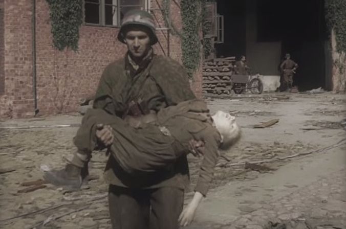 Żołnierz AK niesie na rękach zabitego przez Niemców chłopca, który brał udział w Powstaniu Warszawskim, 1944