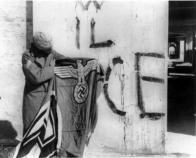 Sikh z czwartej Dywizji Brytyjsko-Indyjskiej ogląda niemiecką flagę, Włochy, 1945