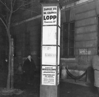Podświetlany słup ogłoszeniowy na przystanku tramwajowym, Krakowskie Przedmieście przy wejściu na teren UW, 1937