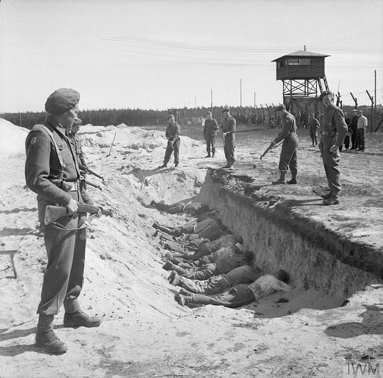 SS-mani z obozu koncentracyjnego Bergen-Belsen zmuszeni przez żołnierzy brytyjskich do leżenia w pustych masowych grobach