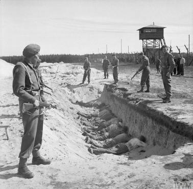 SS-mani z obozu koncentracyjnego Bergen-Belsen zmuszeni przez żołnierzy brytyjskich do leżenia w pustych masowych grobach