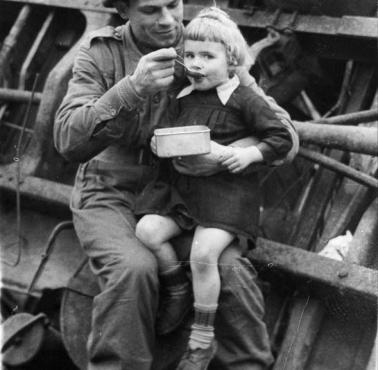 Żołnierz Polskiej Pierwszej Dywizji Pancernej, dowodzonej przez generała Stanisława Maczka, karmi głodne holenderskie dzieci