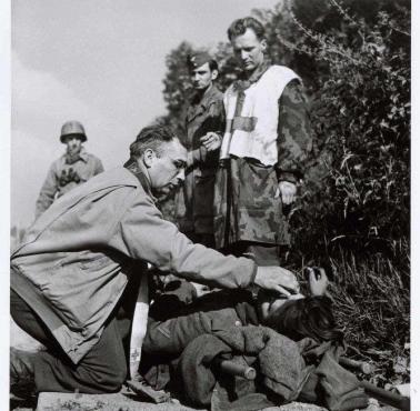 Amerykański kapelan wojskowy przy umierającym niemieckim żołnierzu, Normandia, Francja, 1944