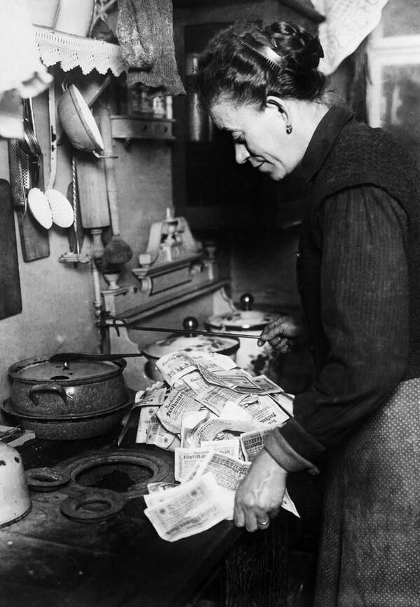 Hiperinflacja w Niemczech. Kobieta pali pieniędzmi pod kuchnią, 1923