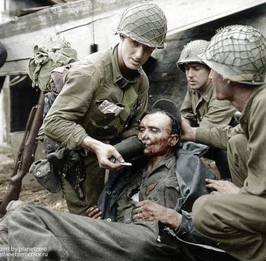 Amerykański żołnierz podaje wodę rannemu Niemcowi, Limay, Francja, 1944