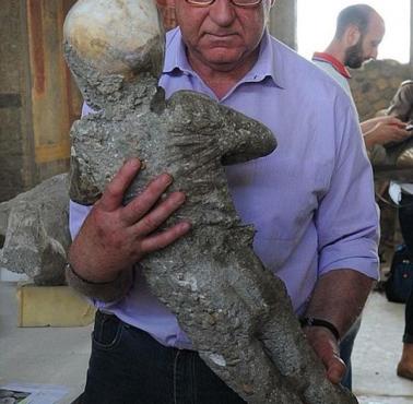 Konserwator niesie odlew gipsowy dziecka z Pompei, które zginęło podczas erupcji Wezuwiusza w 79 roku n.e.