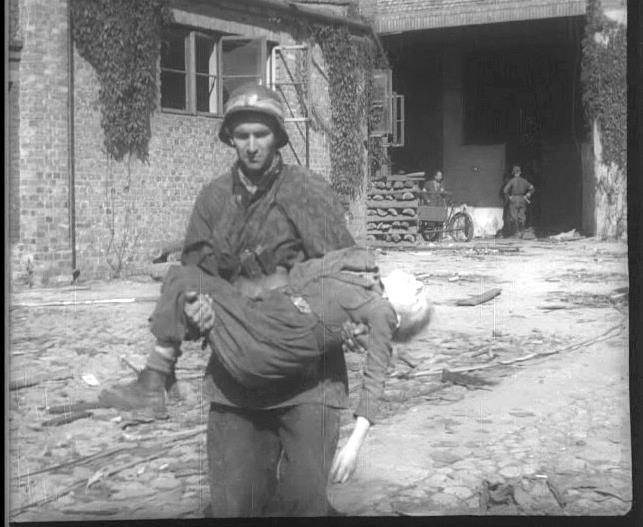 Mieczysław Mirecki ps. Błyskawica niesie ciało 11-letniego Wojciecha Zaleskiego ps.Orzeł Biały, Powstanie Warszawskie, 1944