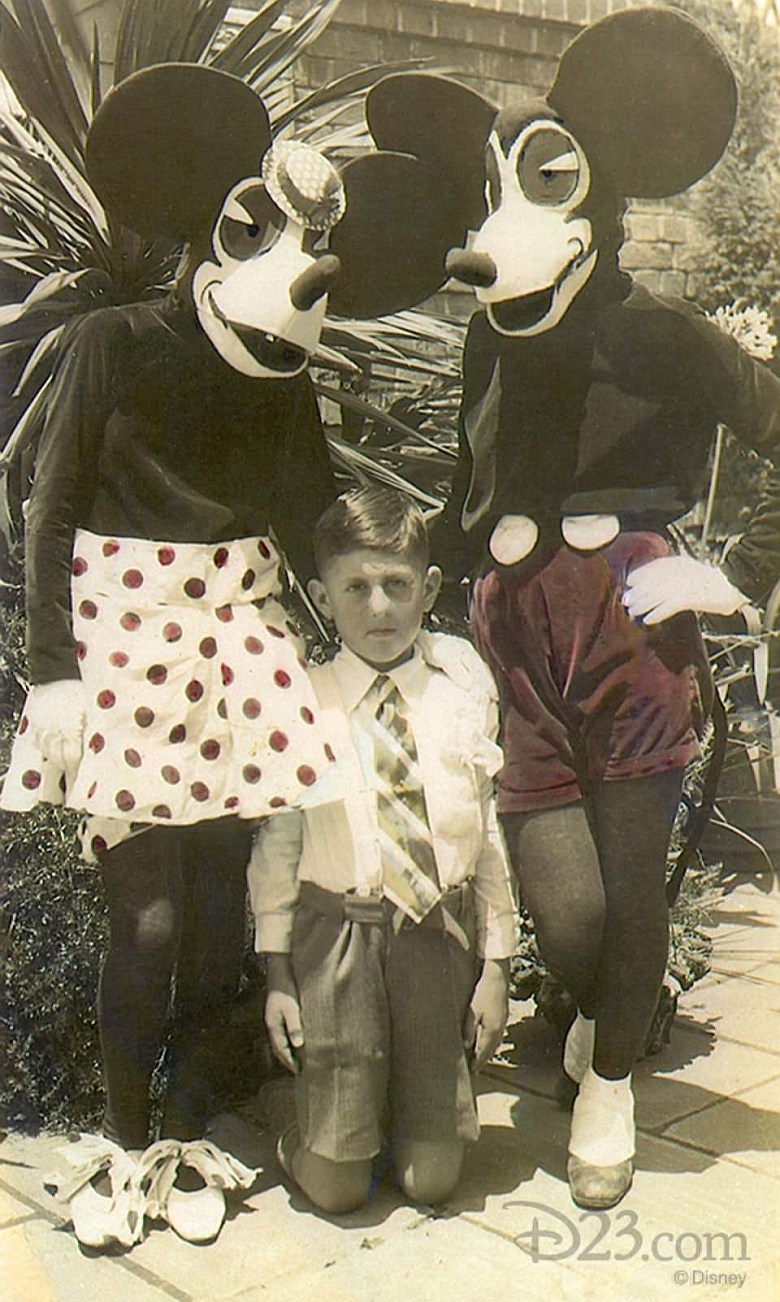 Dziecko pozuje z pierwszymi kostiumami Myszki Miki i Minnie Mouse