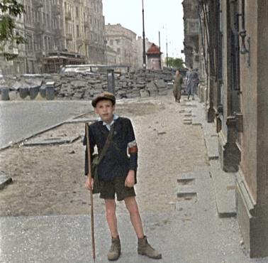 Mały powstaniec stoi na tle barykady przy ul. Marszałkowskiej, Powstanie Warszawskie, 1944