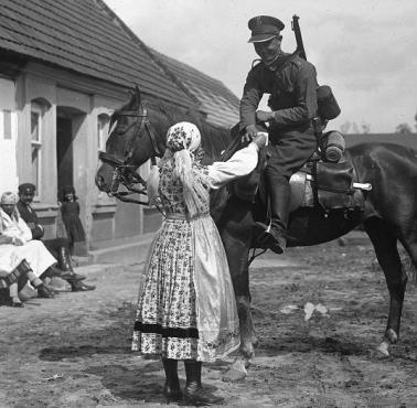 1930. 1 Pułk Szwoleżerów na ćwiczeniach. Konny szwoleżer w wiejskiej zagrodzie - dziewczyna podaje mu wodę