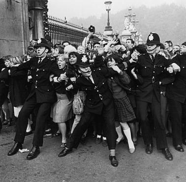 Policja próbuje powstrzymać napierający tłum fanek zespołu The Beatles (Buckingham Palace, Londyn).
