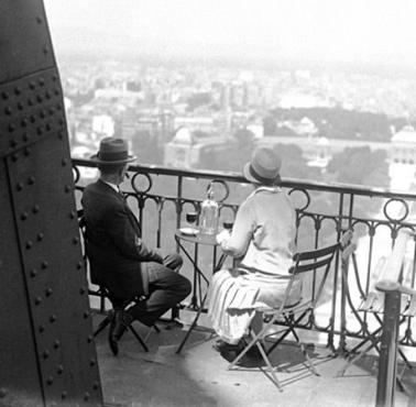 Para delektuje się widokiem na Paryż z wieży Eiffla. 